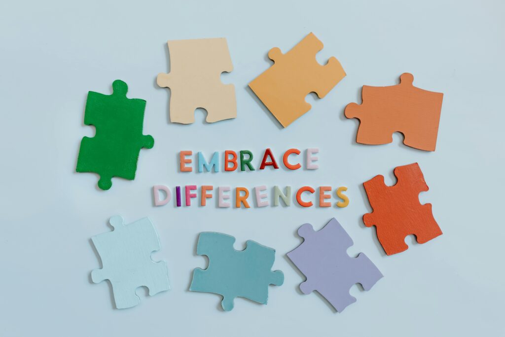 Colorful puzzle pieces on a blue background with the phrase Embrace Differences, symbolizing neurodiverse hiring.